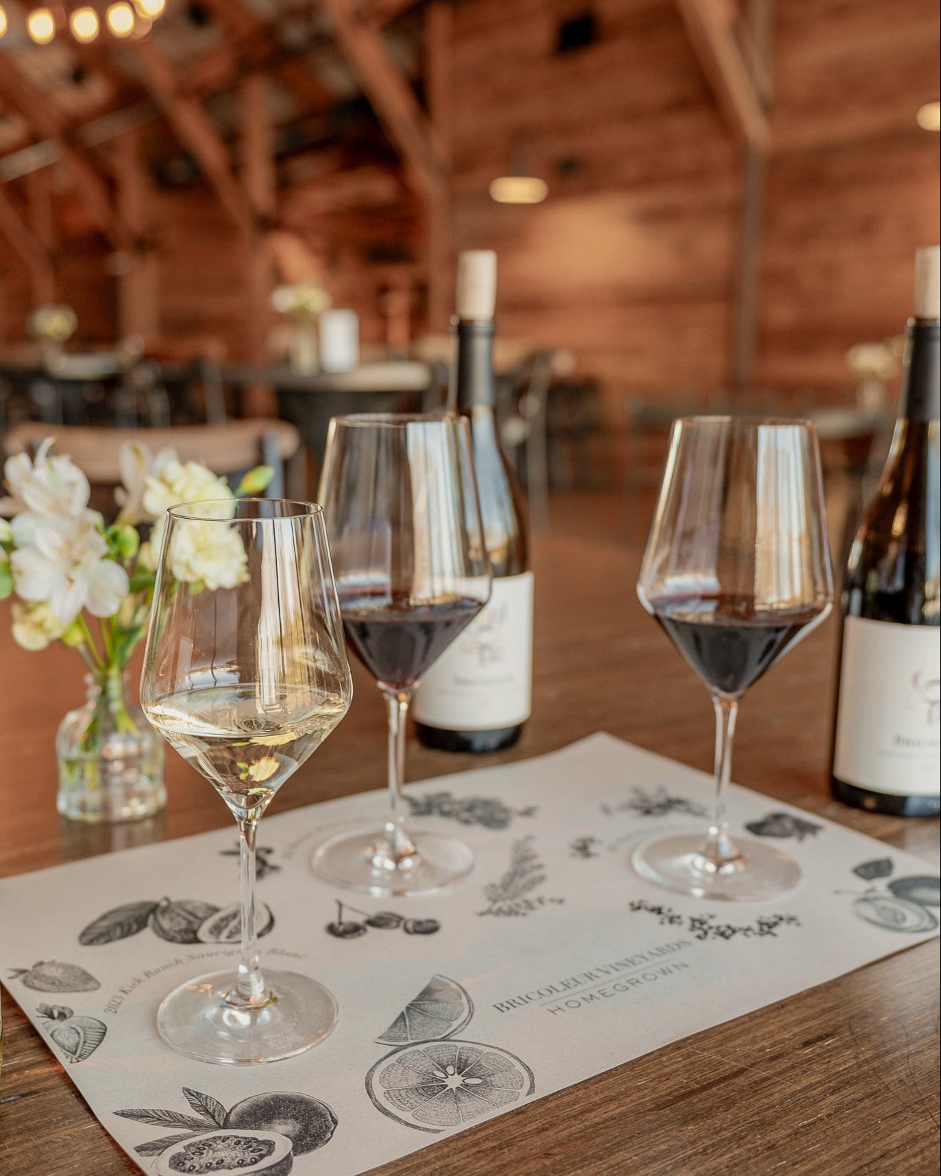 Wine bottles and glasses on a table with a rustic interior background